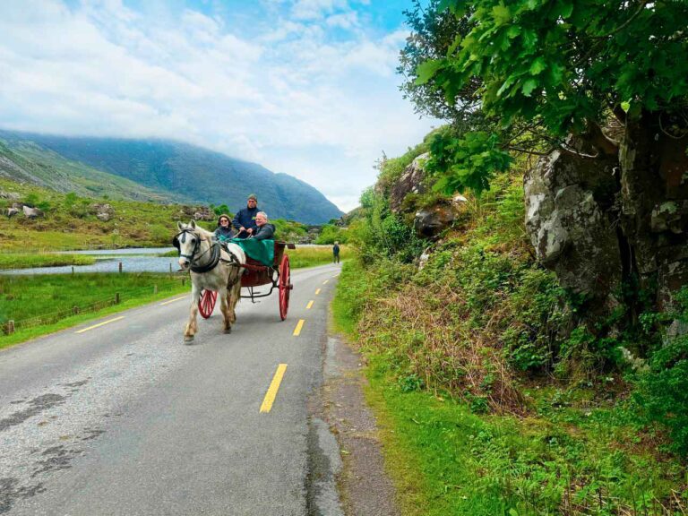 Tourists enjoying a traditional jaunting car ride through the Gap of Dunloe, Killarney, Ireland.